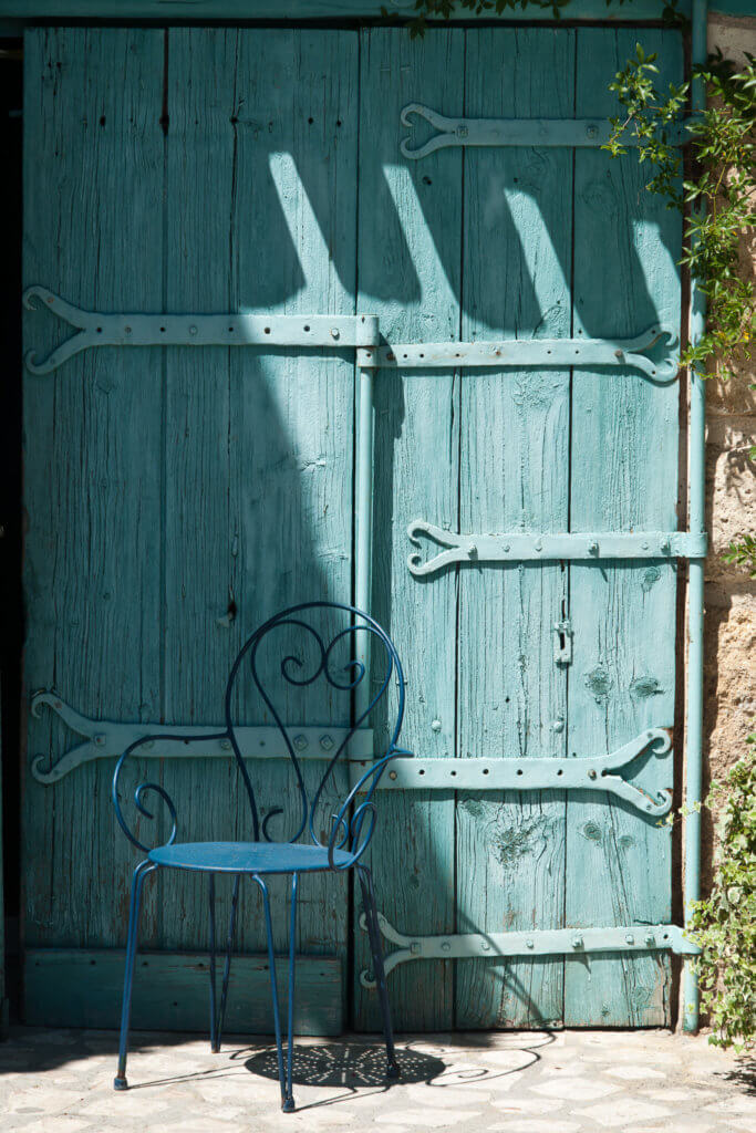 Porte bleu avec chaise en fer